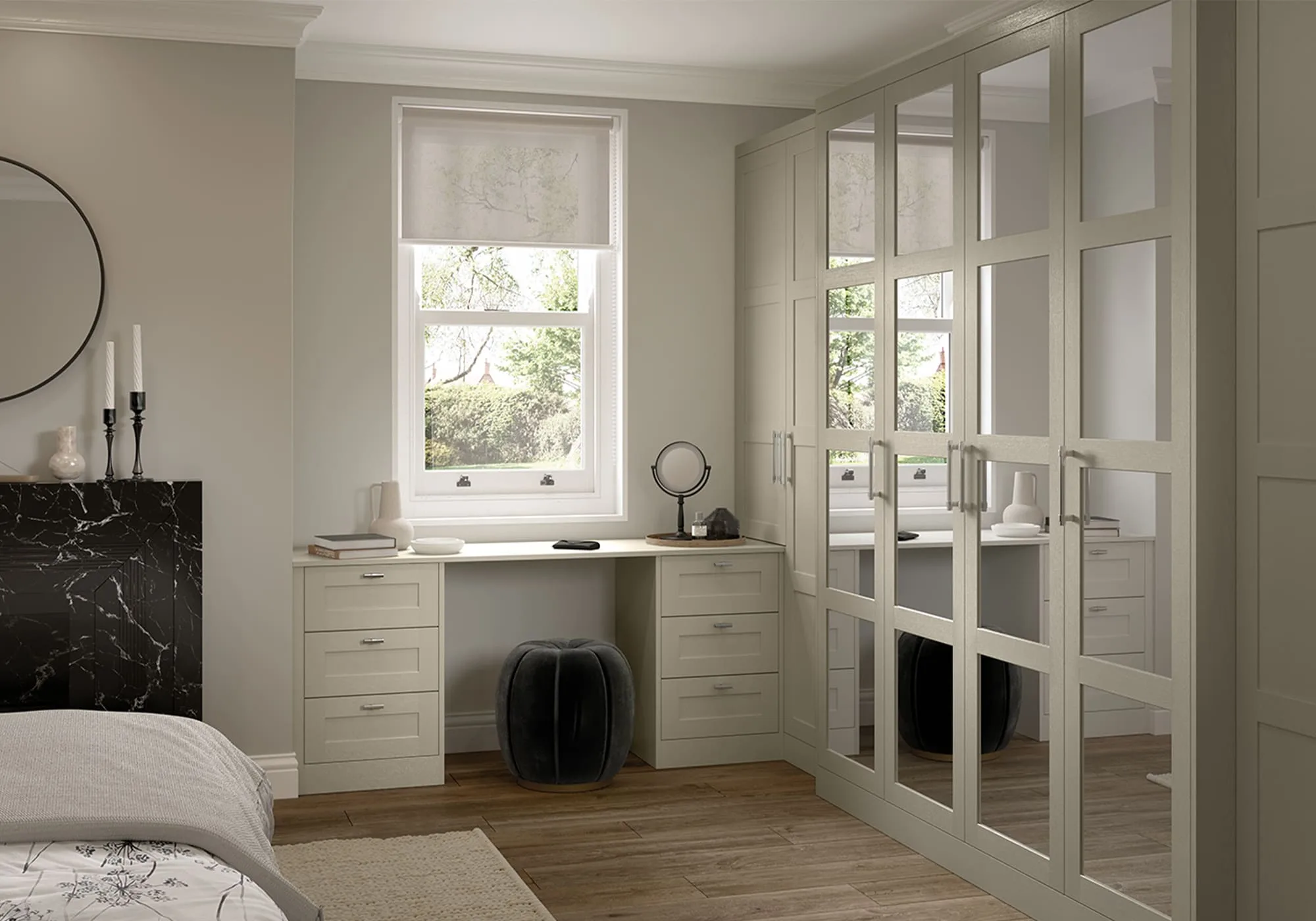 Fitted wardrobes with mirrored panel doors drawn around a bedroom window, with a desk built into the reveal and the cornice run to match