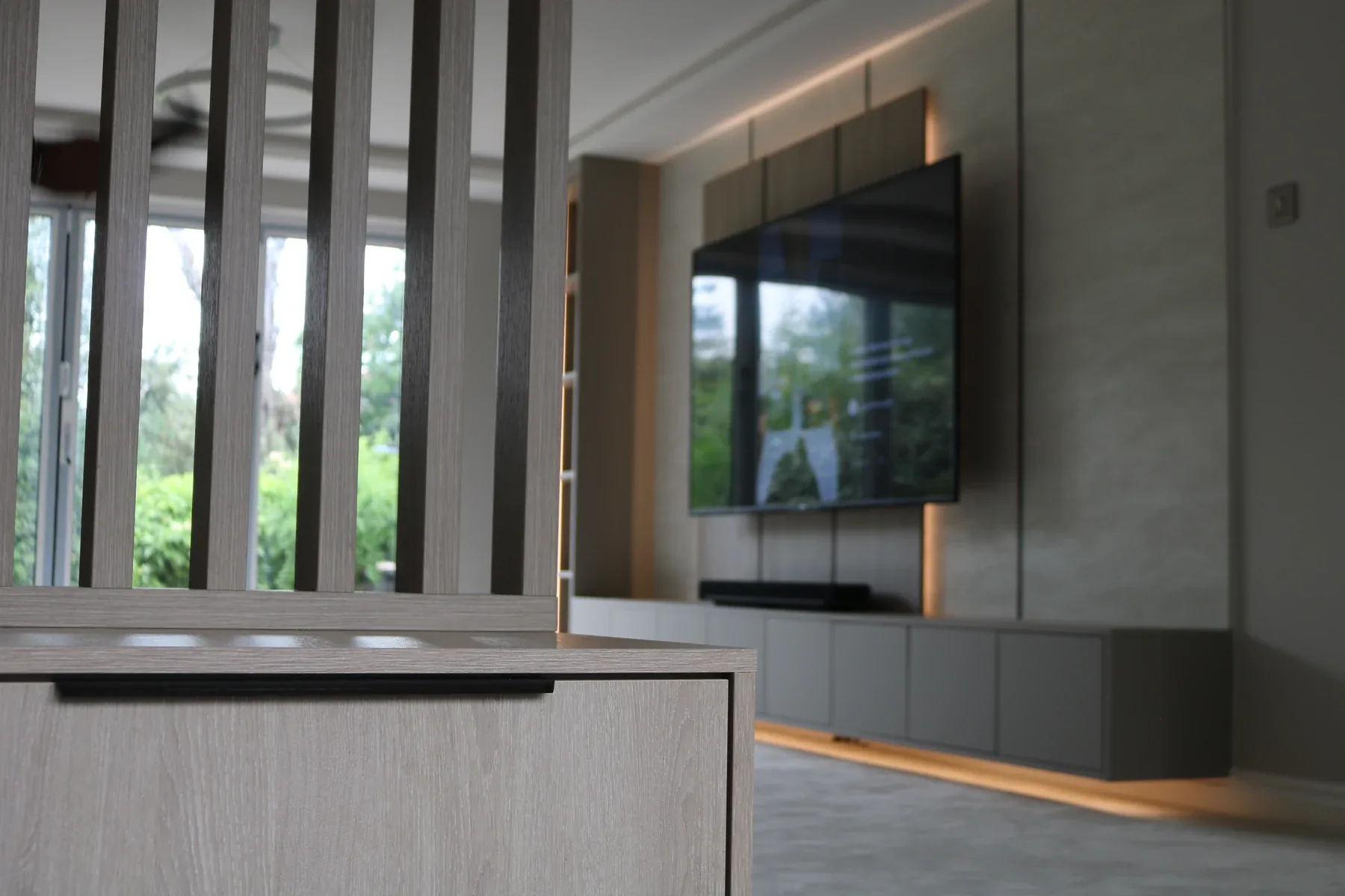 Slatted timber divider with media wall behind, real installation
